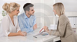 Young couple customers and adviser or agent talking about finance and insurance.