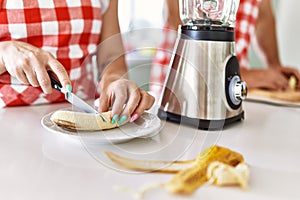 Young couple cutting banana at kitchen