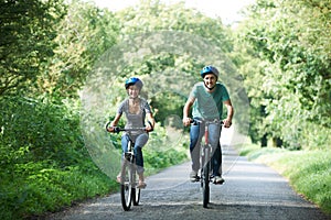 Young Couple Cycling Along Country Lane