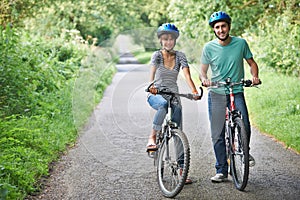 Young Couple Cycling Along Country Road