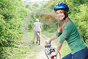 Young Couple Cycling Along Country Track