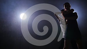 Young couple dance in a dark room with smoke