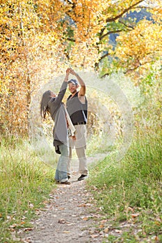 Young couple dancing in fall forest