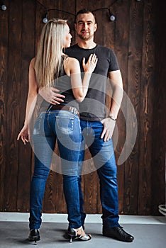 Young couple dancing latin music: Bachata, merengue, salsa. Two elegance pose on cafe with brick walls