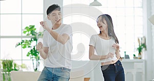 Young couple  dancing in living room at home