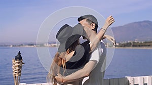 Young couple dancing near the ocean / sea. Sweet girl with boy having fun and dancing together outdoors in honeymoon. Lovers