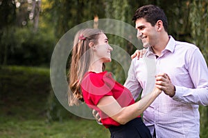 Young couple dancing in the park, holding hands