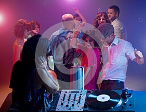 Young couple dancing at party with female dj