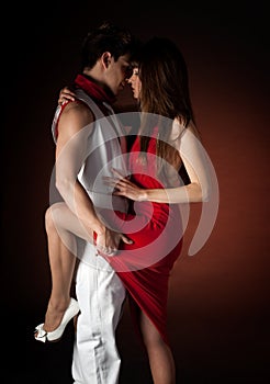 Young couple dancing passion on dark red light