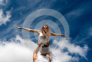 Young couple dancing on sky background, freedom