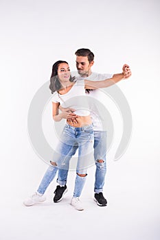 Young couple dancing social latin dance bachata, merengue, salsa. Two elegance pose on white background