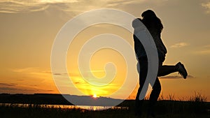 Young couple dancing at sunset on beach. Happy guy and girl waltz in evening in the summer park. Loving man and woman