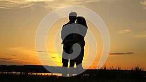 Young couple dancing at sunset on beach. Happy guy and girl waltz in evening in the summer park. Loving man and woman