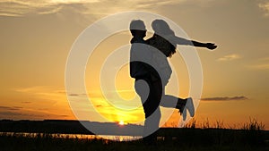 Young couple dancing at sunset on beach. Happy guy and girl waltz in evening in the summer park. Loving man and woman