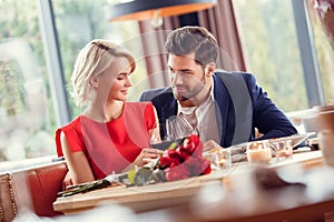 Young couple on date in restaurant sitting drinking wine cheers looking at each other tender