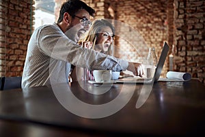 Young couple delighted by content on laptop