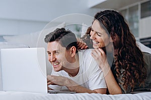 Young couple discusses chosen online purchases at laptop