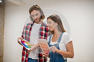 Young couple discussing the color for walls and looking involved