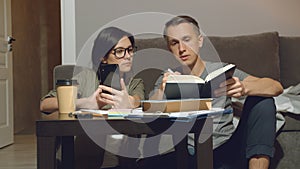 Young couple discussing a joint project or design of a new apartment working together sitting on the floor at home