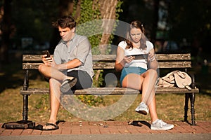 Young couple distracted with communication technology tablet and photo