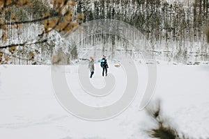 The young couple with dog haski at forest nature park in winter. Travel adventure concept