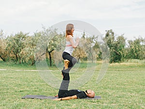 Young couple doing acro bird yoga pose. Healthy lifestyle modern activity.