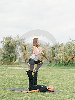 Young couple doing acro bird yoga pose. Healthy lifestyle modern activity.