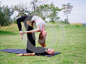 Young couple doing acro bird yoga pose. Healthy lifestyle modern activity.