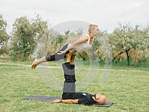 Young couple doing acro bird yoga pose. Healthy lifestyle modern activity.