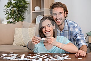 Young couple doing jigsaw puzzle at home