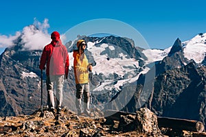 Young couple doing Nordic walking in the mountains, rear view. An active couple is engaged in Hiking.