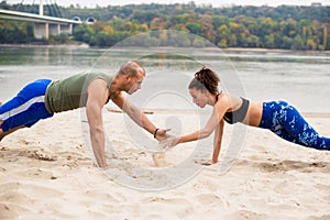 Young couple doing sports training on the beach