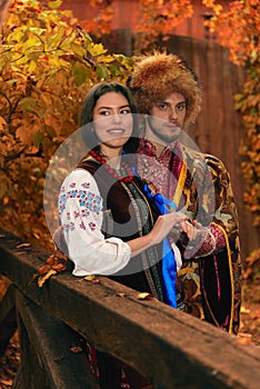 Young couple dressed traditional ukrainian clothing. Cossack man and smiling woman in embroidered costumes outdoors