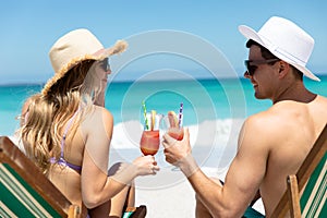 Young couple drinking at the beach