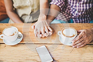 Young couple drinking cappuccino at bar coffee shop - People holding each others hands for tender love moments - Relationship