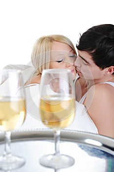 Young couple drinking champagne in bed
