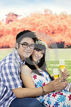 Young couple drinking champagne at the park