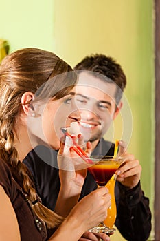 Young couple drinking cocktails in