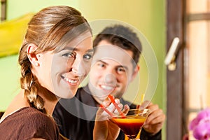 Young couple drinking cocktails