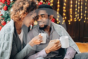 Young couple drinking coffee and enjoying Christmas morning