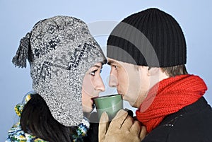Young couple drinking hot drink from same cup