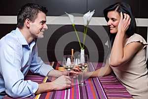 Young couple drinking wine and flirting