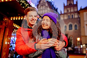 Young couple with drinks on Christmas market
