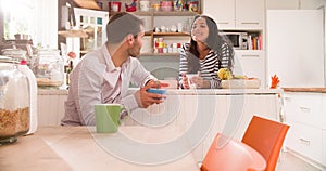 Young Couple Eating Breakfast In Kitchen Together