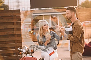 young couple eating french fries and burger