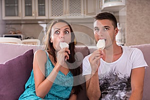 Young Couple Eating Ice Cream Bars and Watching TV