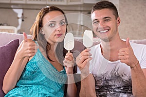 Young Couple Eating Ice Cream and Giving Thumbs Up