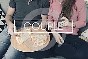 Young couple eating pizza with sign