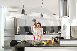 Young Couple Embrace In Kitchen, Hispanic Man And Asian Woman Hug