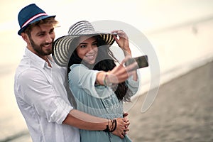 Young couple in an embrace  on sea beach make selfie